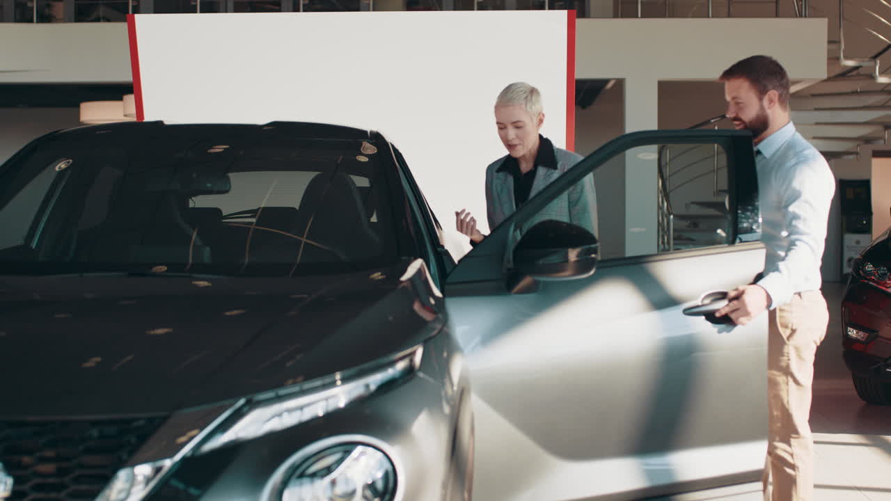 고객이 자동차 대리점에서 새로운 suv를 보고 있습니다.