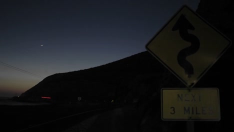 una toma de lapso de tiempo de tráfico en la noche pasando un roadsign