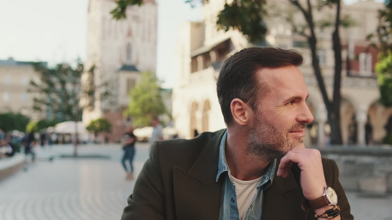 Uomo sorridente in una piazza cittadina