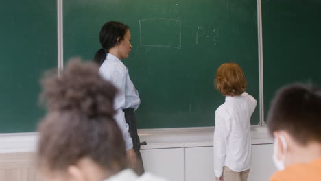 Lehrer-Und-Schüler-An-Der-Tafel.