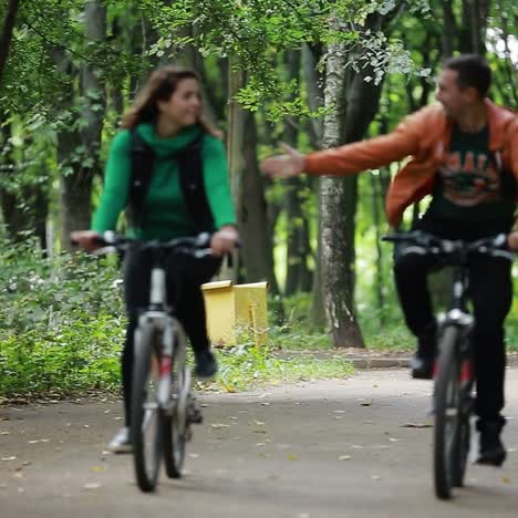 young couple cycling in park