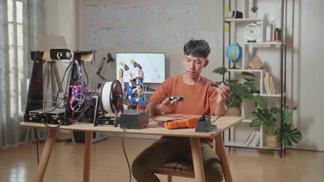 joven aprendiendo a reparar impresoras 3d y manos robóticas