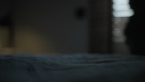 person making a bed at night