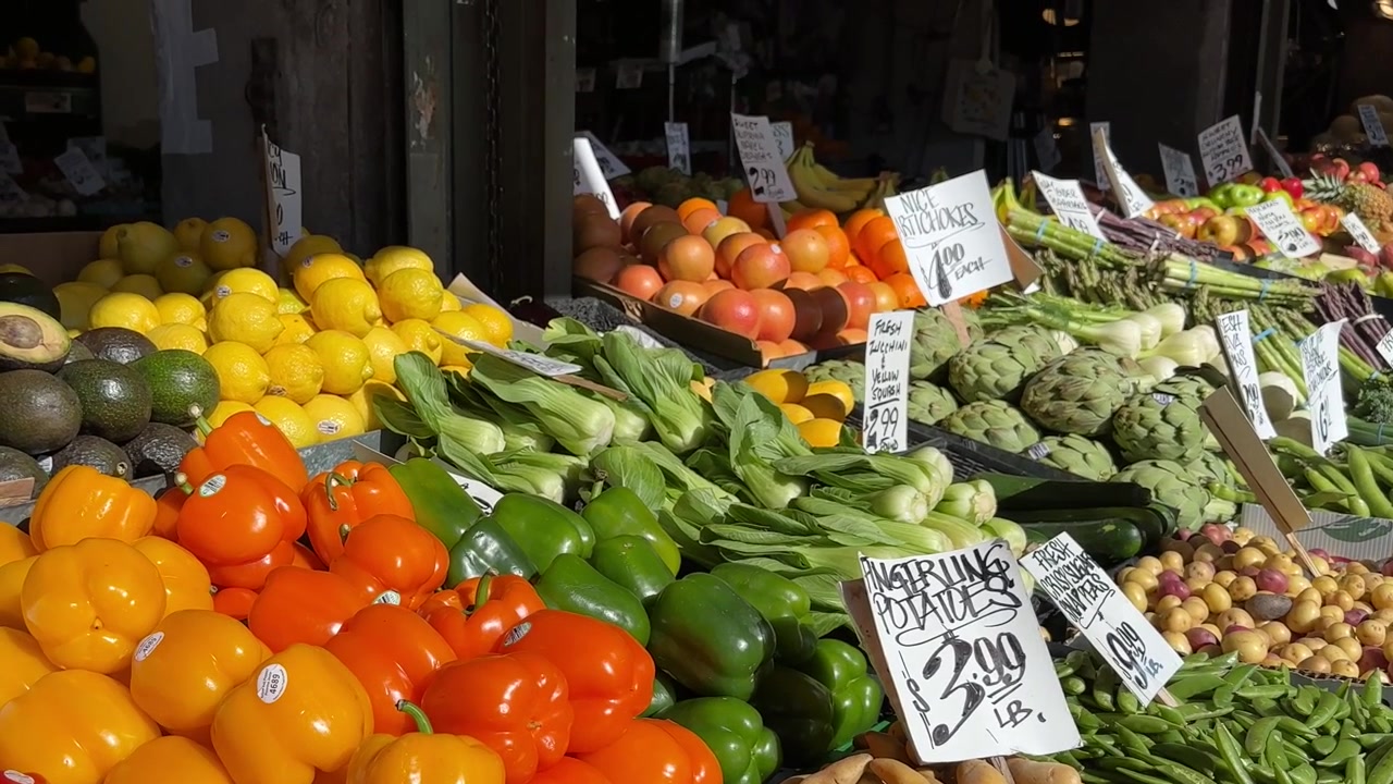 Seleção colorida de vegetais orgânicos frescos em exposição em banca de feira com etiquetas de preço escritas à mão