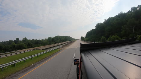 Rooftop-view-of-driving-on-a-divided-highway-past-heavily-timbered-landscape-in-rural-Alabama