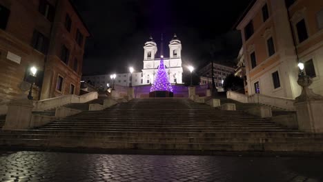 Spanish-Steps-in-Rome,-Italy-at-night-with-man-walking-away