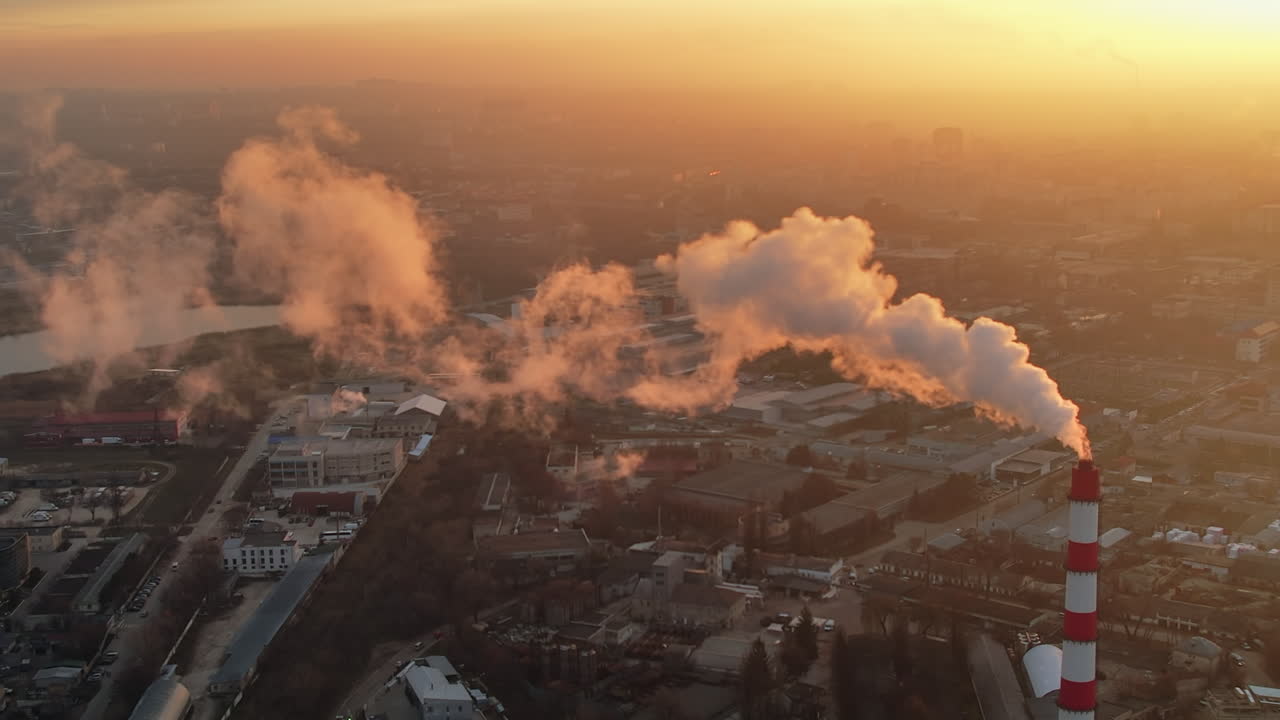 Aerial drone view of thermal power plant in Chisinau at sunrise, Moldova. View of pipe with felling steam, cityscape