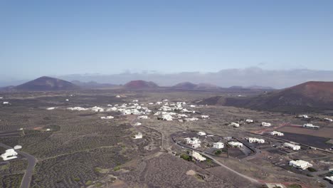 toma aérea de un pequeño pueblo del desierto, edificios blancos y montañas en un día soleado