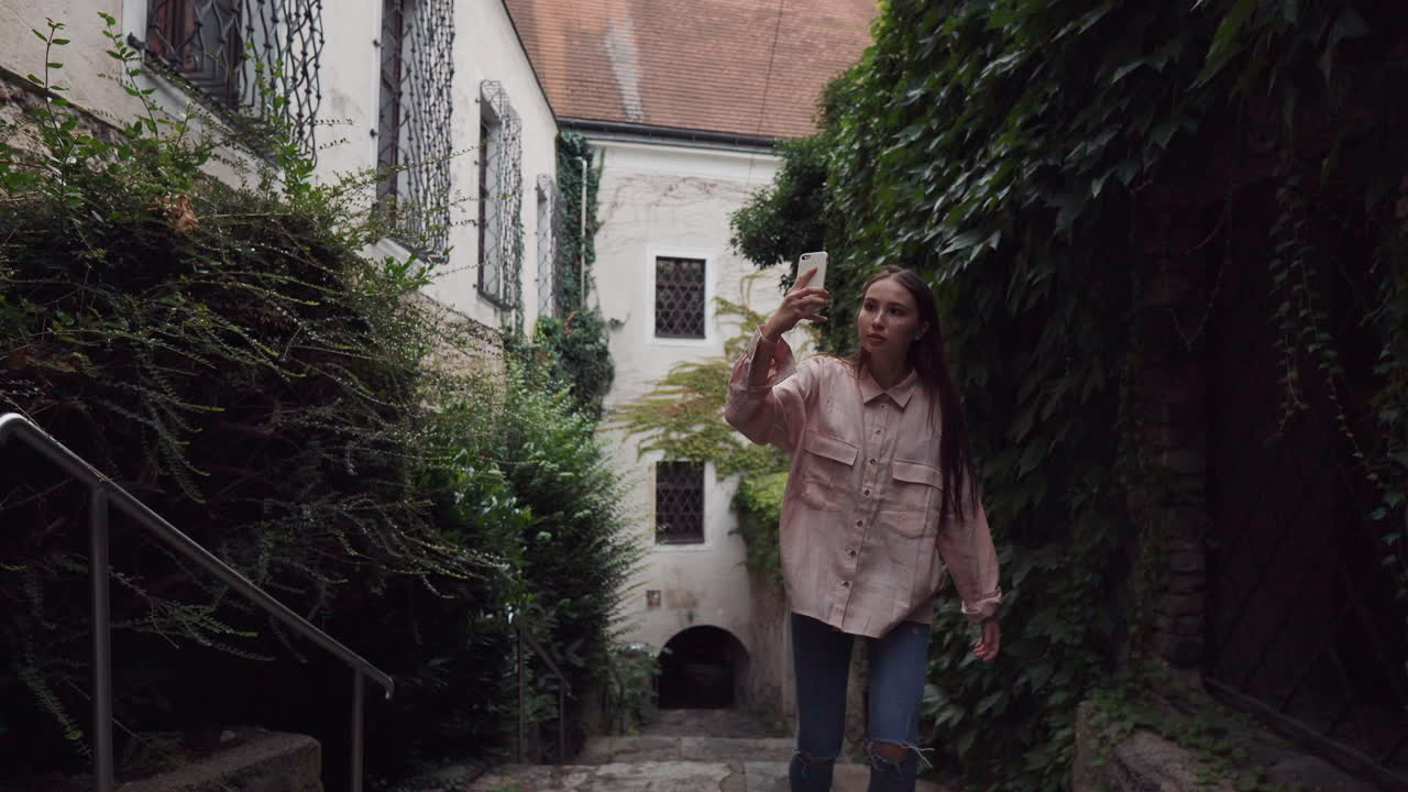joven tomando una foto en una antigua ciudad europea