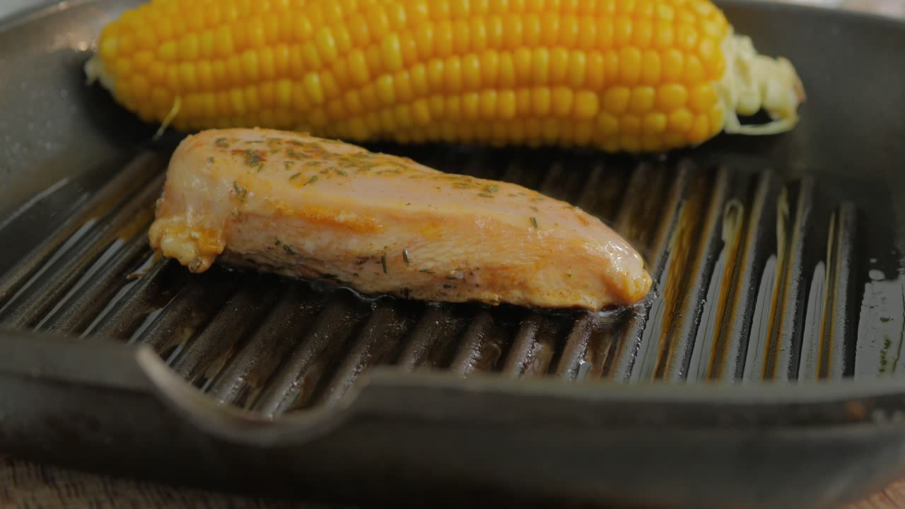 pechuga de pollo deliciosamente sazonada en una parrilla de hierro caliente que se voltea con un tenedor