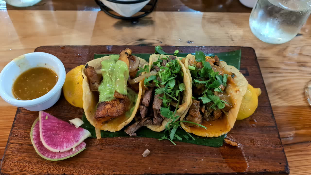 tacos deliciosos y una salsa de inmersión servida en una hoja de plátano