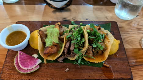 delicious tacos and a dipping sauce served on a banana leaf