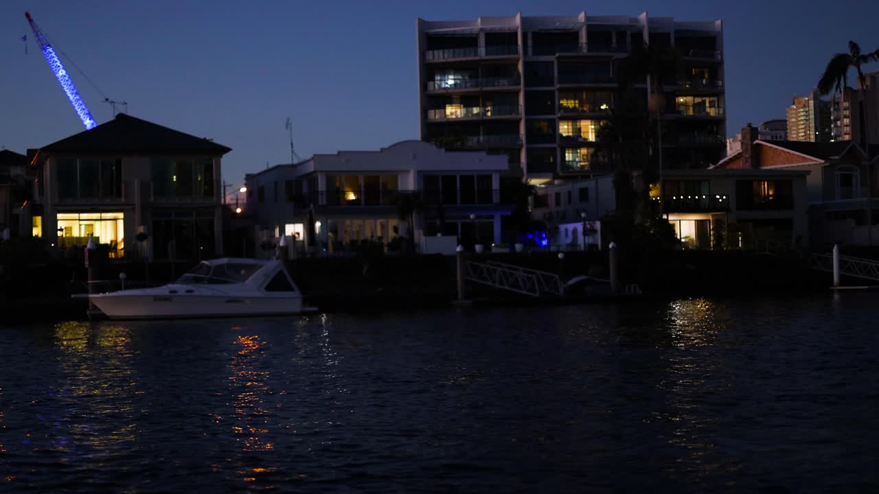 야간 에 해안 건물 을 지나가는 요트