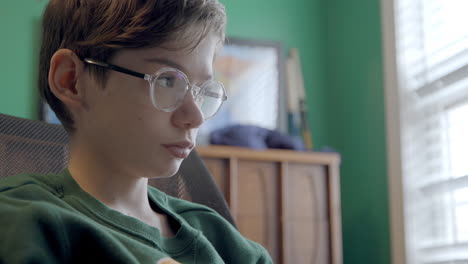 retrato de un joven atractivo con anteojos estudiando en su dormitorio