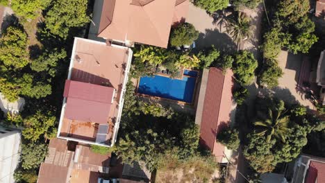 descending rotating drone shot of a tropical hotel grounds and swimming pool