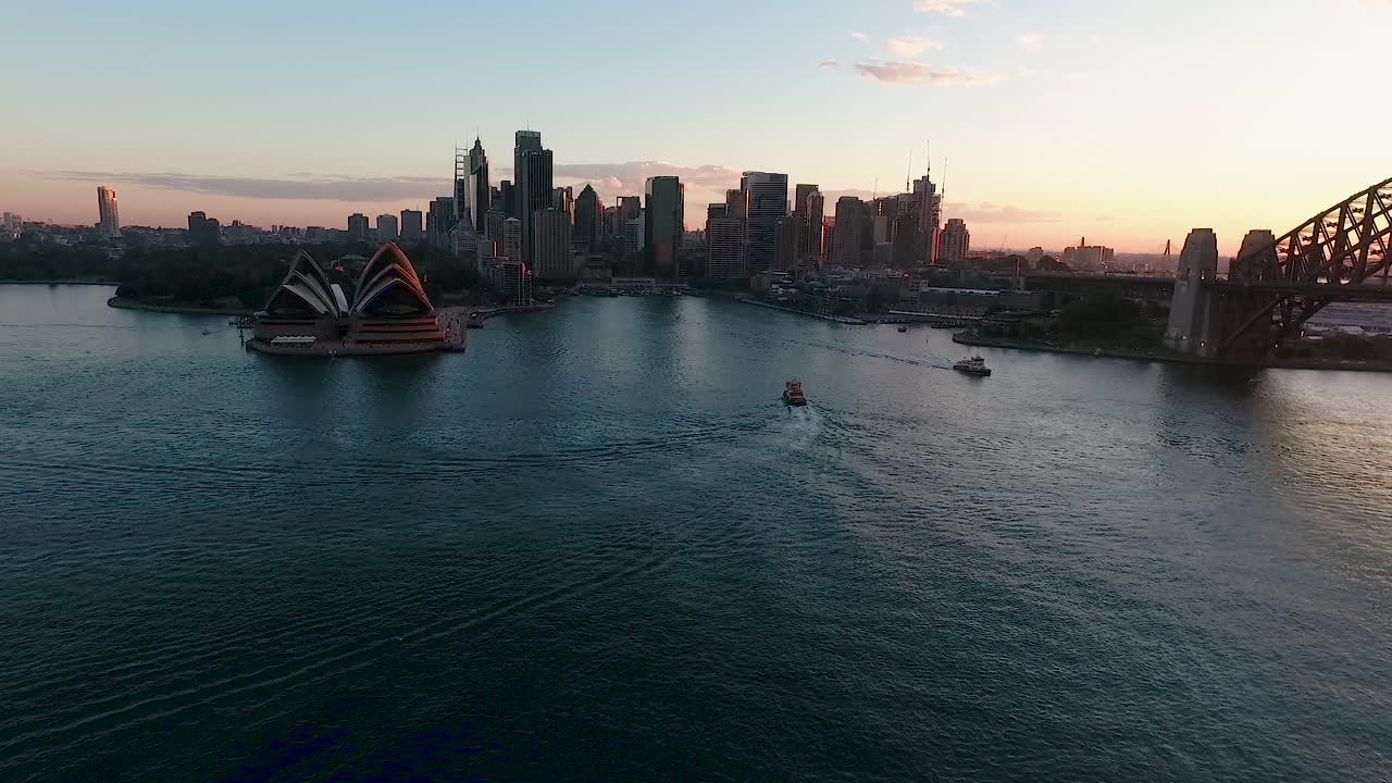 Drone View Of Iconic Sydney Harbor At Sunset, Ferries Crossing Slow Motion