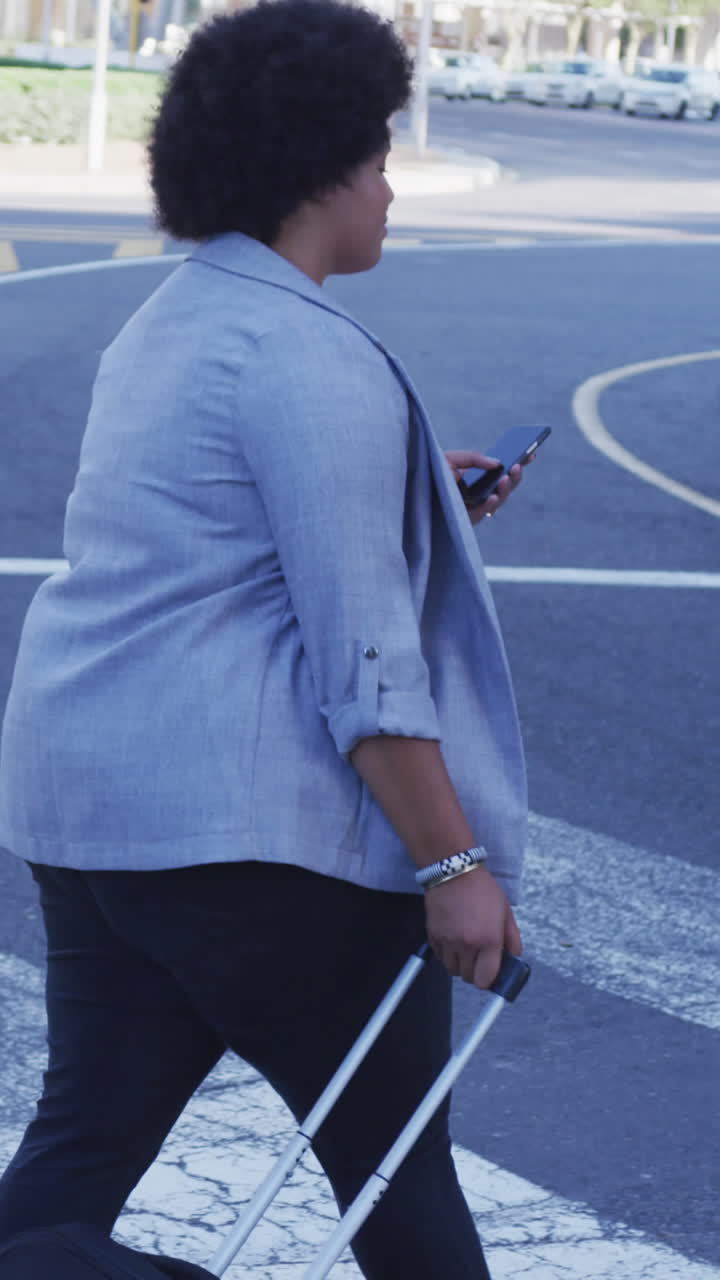 Happy plus size biracial woman walking with luggage on street