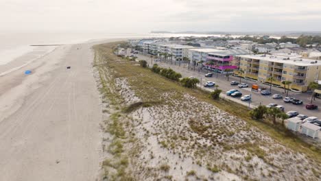 Drone-of-an-empty-beach-in-Tybee-Island-approaching-shops-during-warm-sunny-day