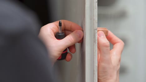 man installing a door handle on a cabinet door