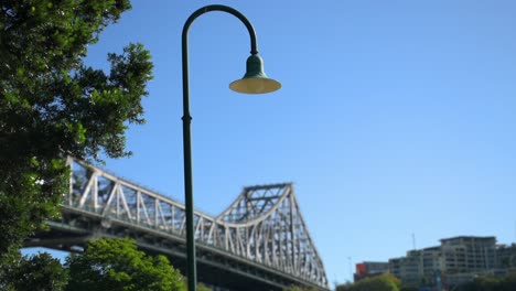 Atemberaubende-Schärfentiefe-Aufnahme-Eines-Alten-Laternenpfahls-Mit-Der-Berühmten-Story-Bridge-Von-Brisbane-Im-Hintergrund,-In-Queensland,-Australien