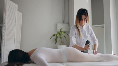 adult woman is relaxing during anti-cellulite massage in beauty clinic body care and apparatus lost weight