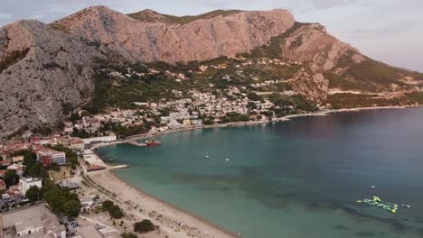 Casas-En-Las-Laderas-De-Las-Montañas-Dinara-Y-Velika-Plaza-Punta-Frente-A-La-Playa-De-Omis,-Croacia