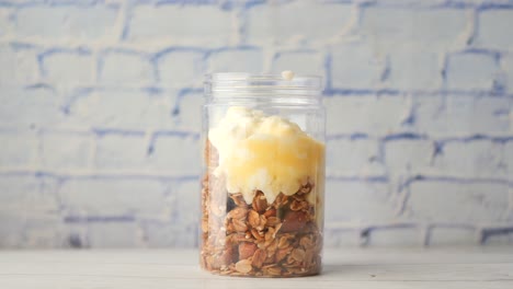 Putting-yogurt-in-granola-musli-in-a-bowl