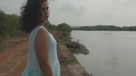 Close-up-of-a-woman-near-the-river-with-looking-towards-the-camera