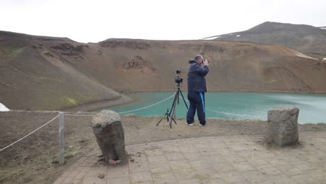 male photographer at krafla volcano in iceland with gimbal video walking up