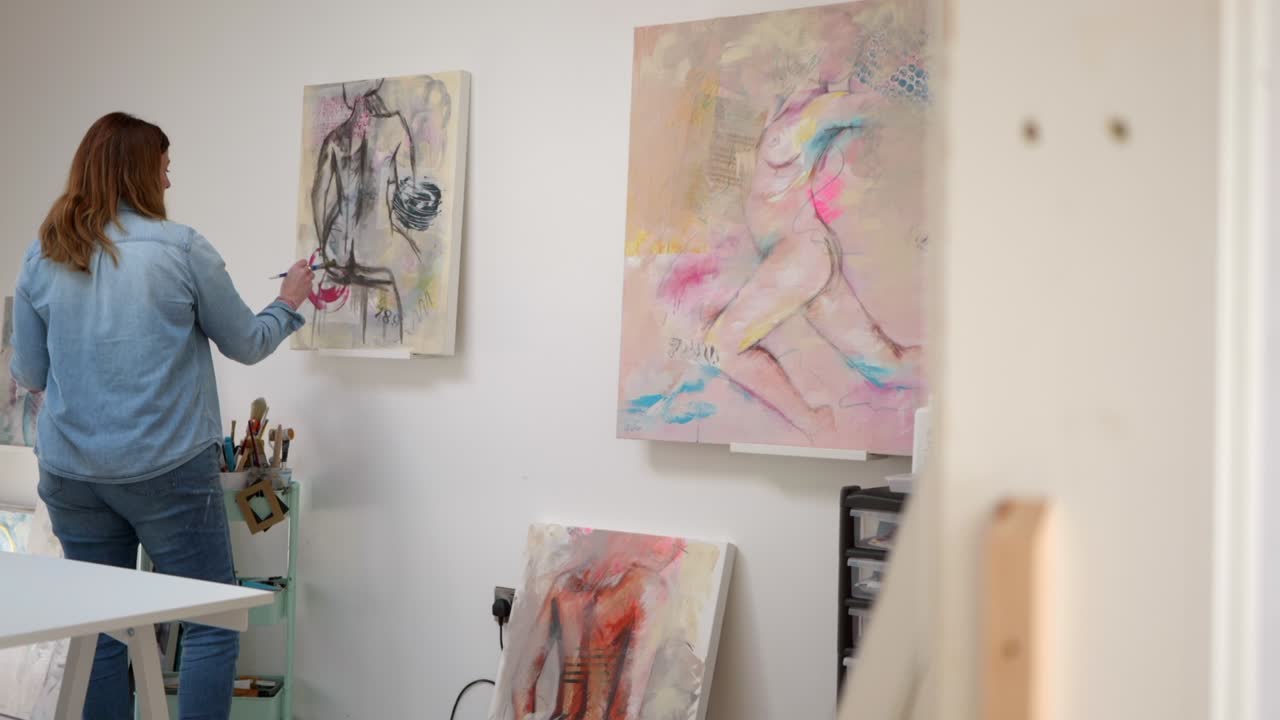 figura de pintura de artista femenina en un lienzo, de pie en un estudio casero
