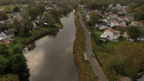 An-aerial-drone-shot-over-a-reflective-pond-on-a-cloudy-afternoon