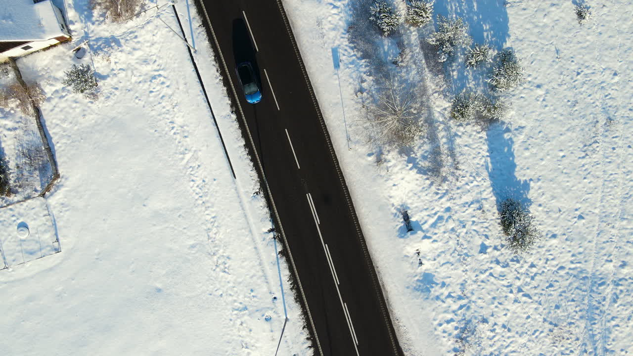 tráfico ligero en la estrecha carretera asfaltada entre el campo nevado cerca de la ciudad de gdansk en polonia