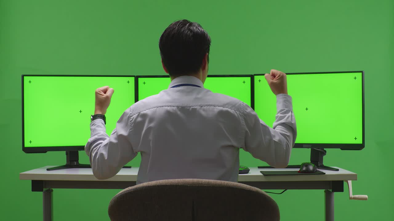 비즈니스맨이 녹색 스크린 모니터로 성공을 축하하고 있습니다.