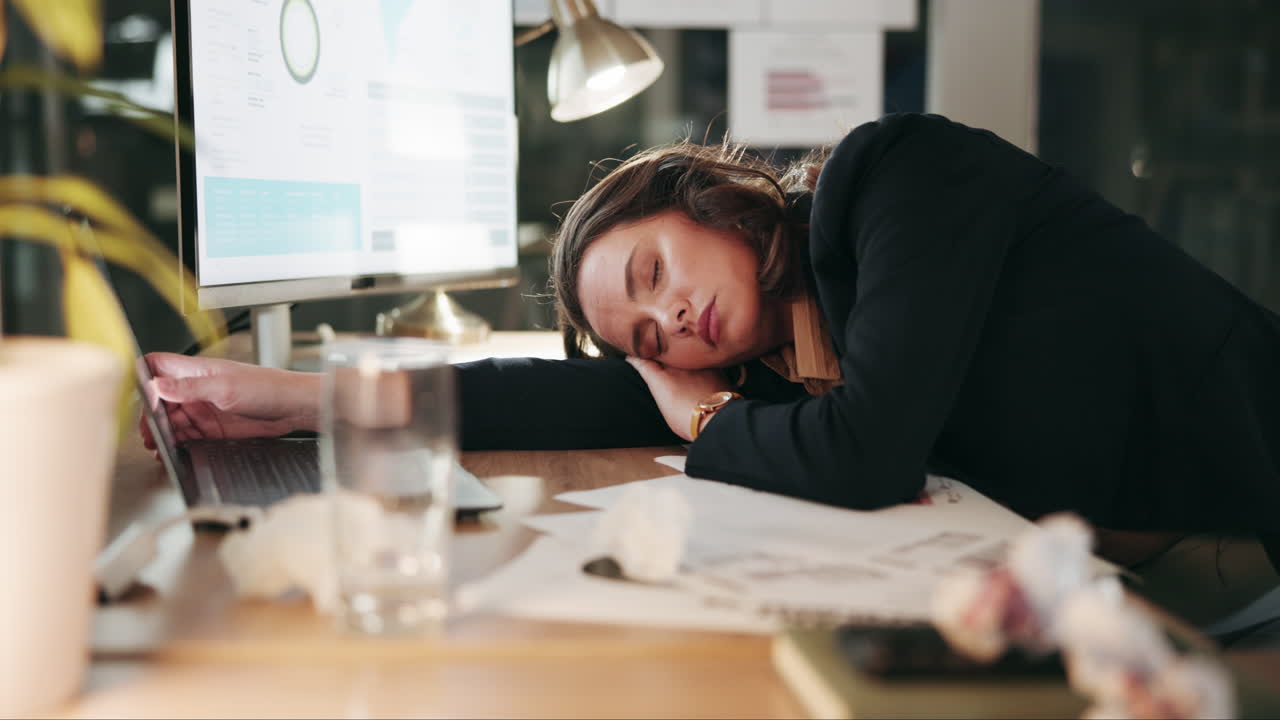 Woman sleeping at her desk after a long day at work