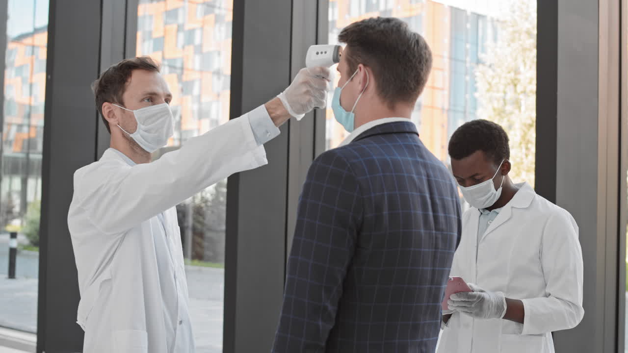 trabajadores médicos comprobando la temperatura de los hombres de negocios