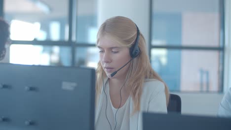 serious young female operator in headset talking to customer