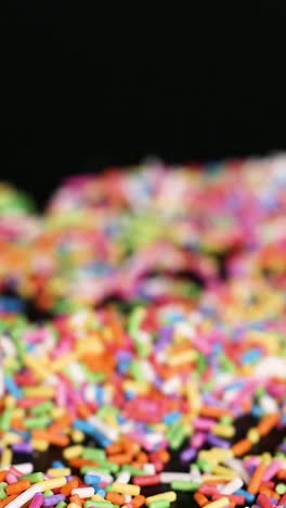 hands interacting with colorful sprinkles on surface