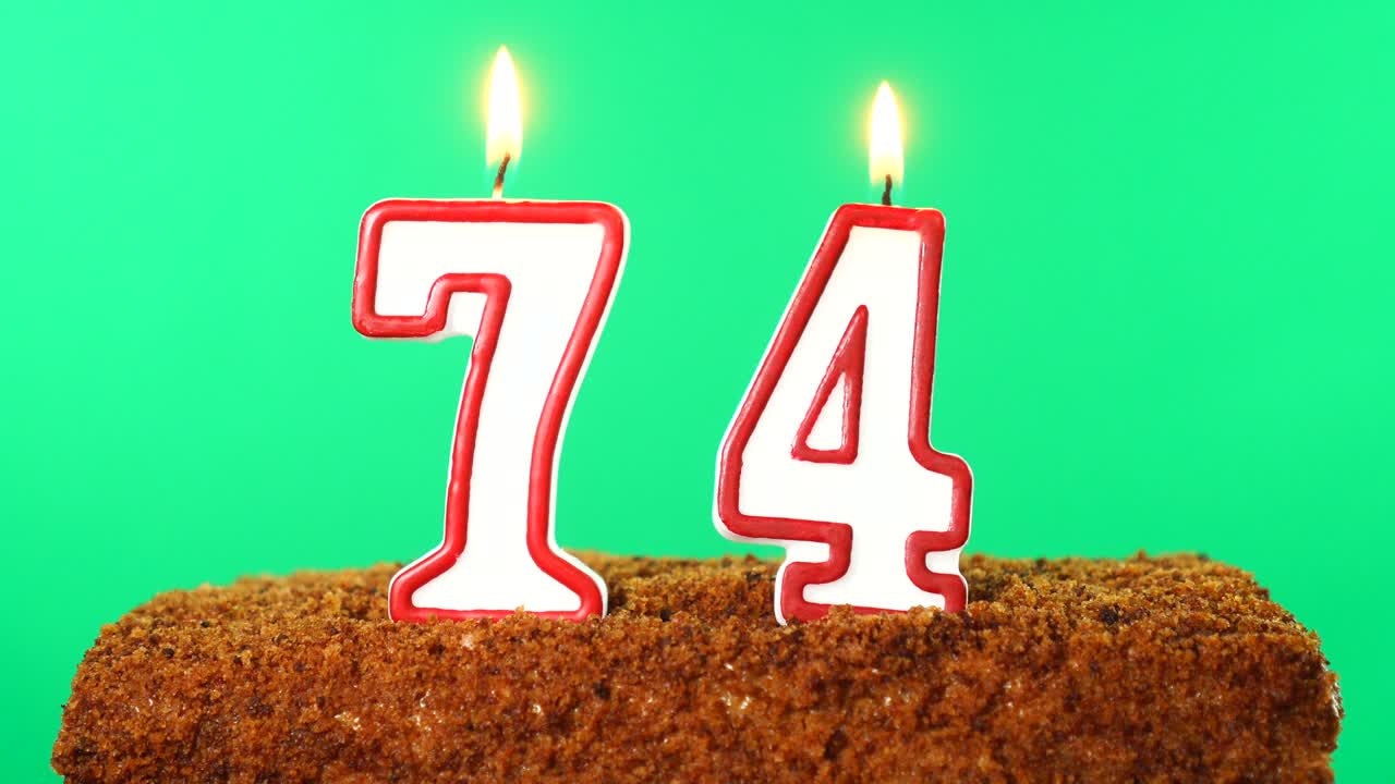 Cake with the number 74 lighted candle. Chroma key. Green Screen. Isolated