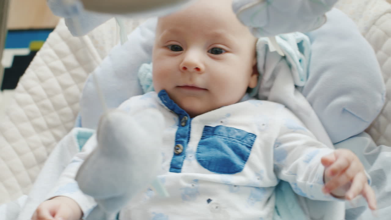 아기가 요람에 있는 작은 두 달 그는 웃으며 잠을 자지 않는다
