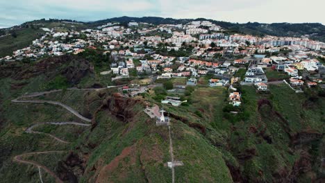 Establishing-aerial-view-towards-Ponta-du-Garajau-green-island-coastline,-Madeira,-Portugal