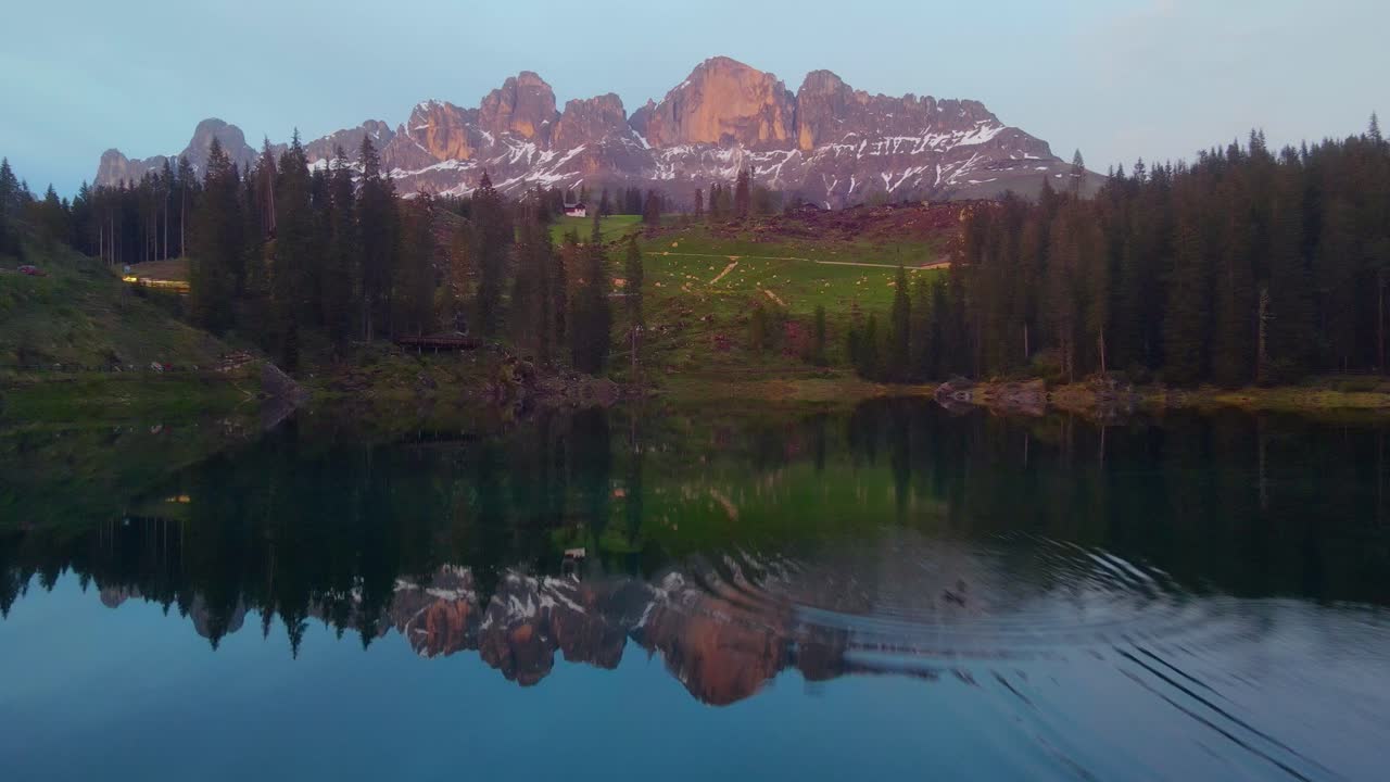 A cinematic view of the breathtaking beauty of Mother Nature's artwork, featuring majestic towering mountains, a pristine blue sky, lush greenery, and a captivating clear lake