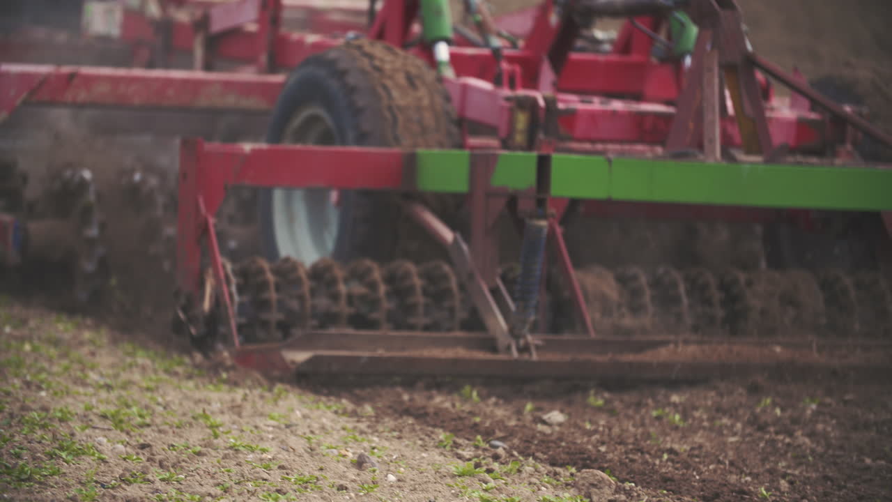 Macchina agricola che coltiva il terreno in un campo rurale