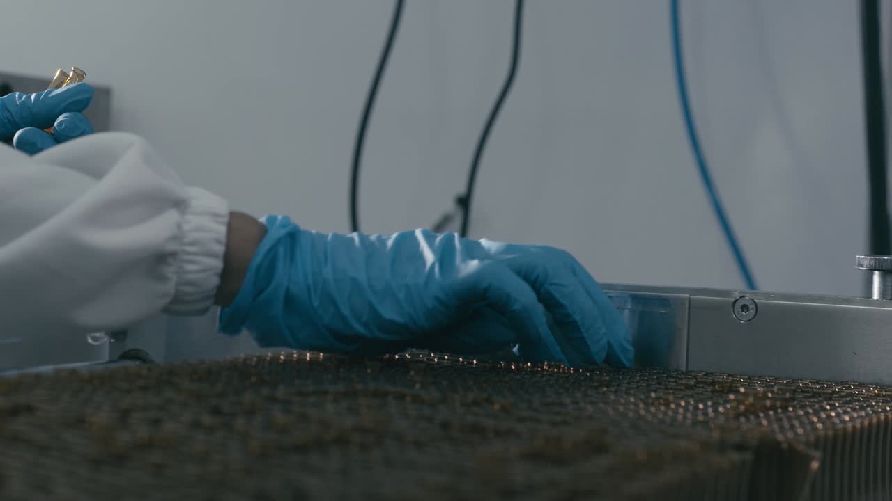 Lab worker arranges bottles containing chemical liquids in a modern pharmaceutical manufacturing factory