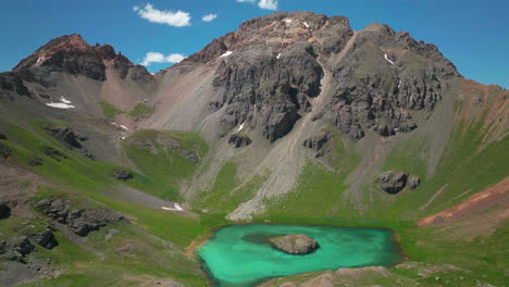 Cinematic-aerial-drone-high-elevation-dreamy-heavenly-Island-Lake-Silverton-Ice-Lake-Basin-unreal-Caribbean-aqua-blue-Silverton-Colorado-summer-snow-melting-Rocky-Mountains-slowly-circling-left