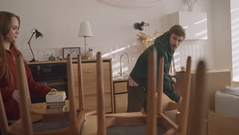 pareja moviendo muebles y desempaquetando cajas