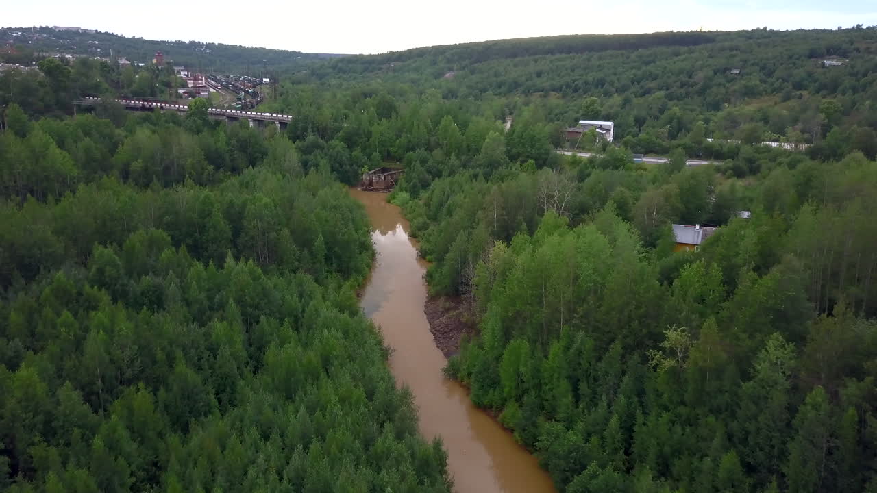 Ilmakuva joesta ja sillasta metsämaisemassa