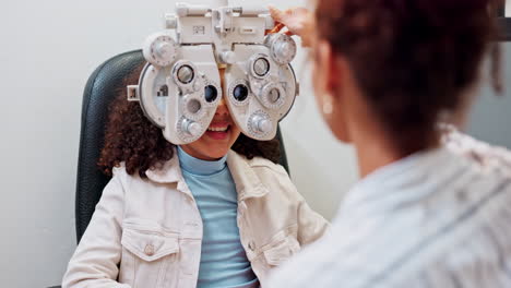 child undergoing an eye exam with a phoropter