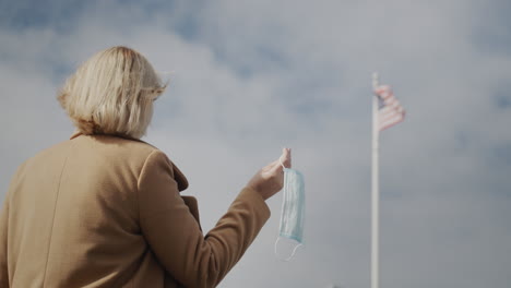 woman with a protective mask in her hand, end of quarantine concept.