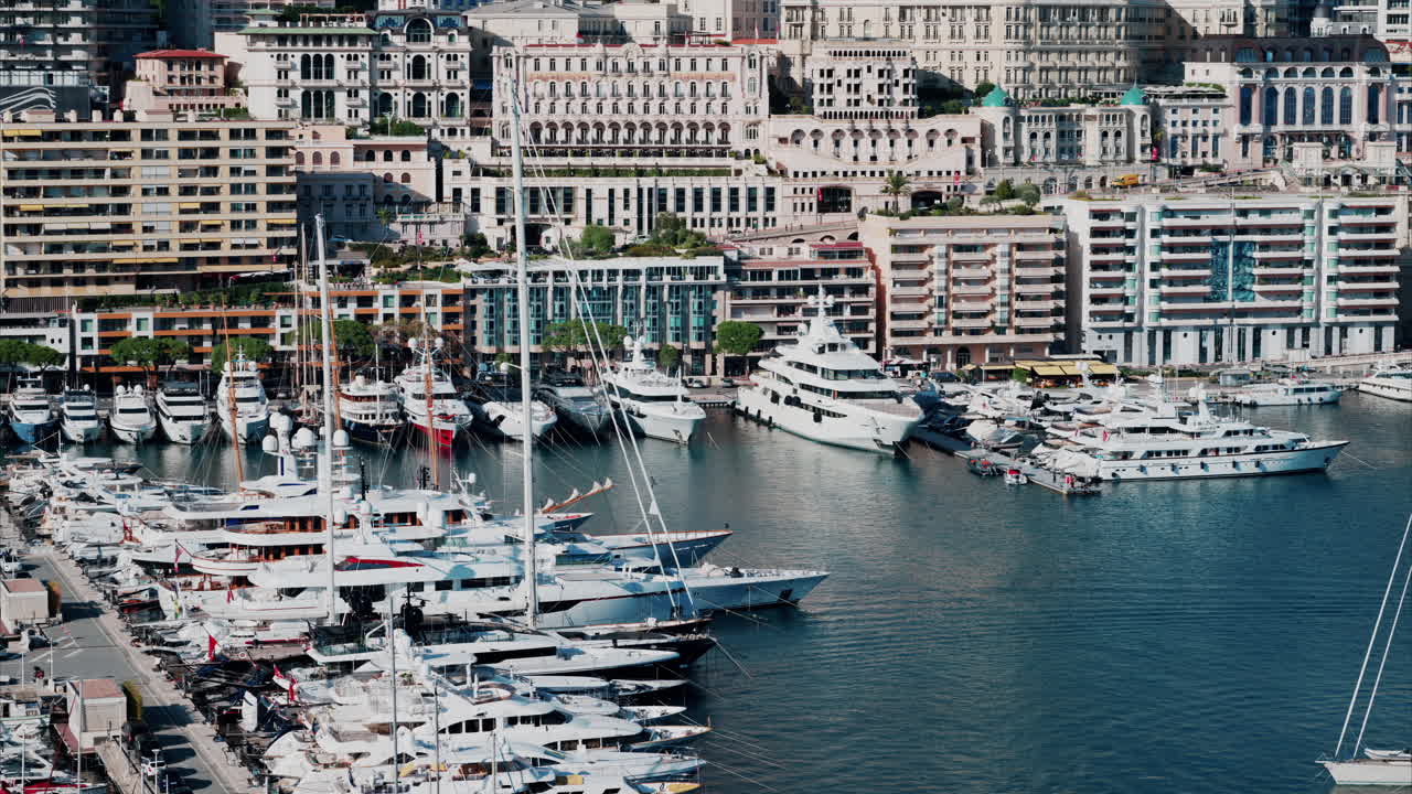 Aerial view of boats docked in the Monaco Marina with the skyline of the city on the background