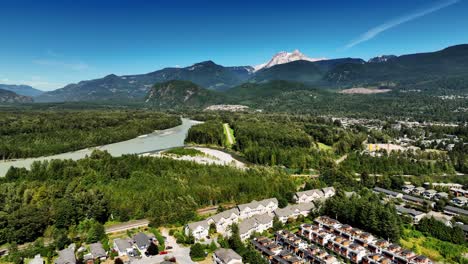 aerial view of squamish town residential houses, river, and mountains in british columbia, canada